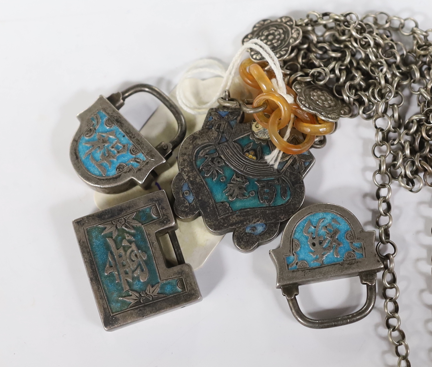 A Chinese white metal and enamel pendant on chain, overall 56cm and three similar padlocks.